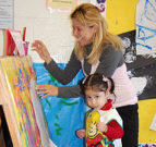 Teacher painting with young student
