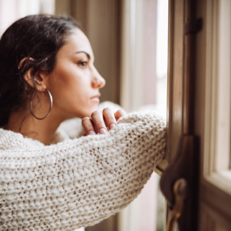 woman looking out her window