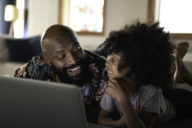 Father and daughter using a computer having fun
