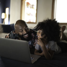 Father and daughter using a computer having fun