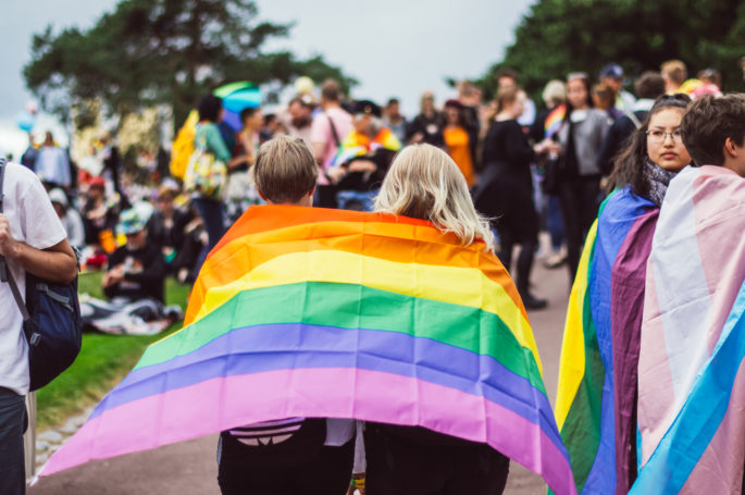 Two girls with rainbow flag in Kaivopuisto garden