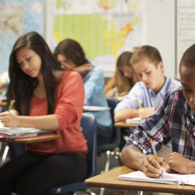 diverse highschool students doing their classwork at their desks
